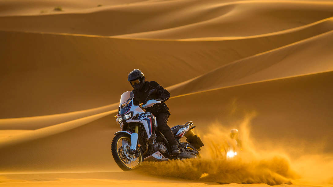 Motocykl Africa Twin při jízdě pouštním pískem