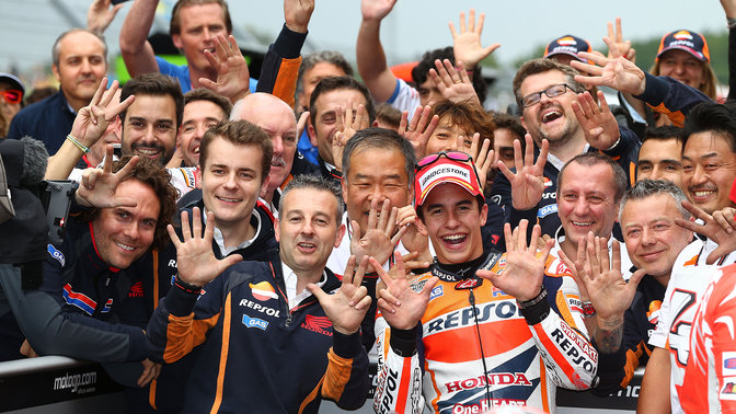 Závodník seriálu MotoGP slavící vítězství se svým týmem Honda.
