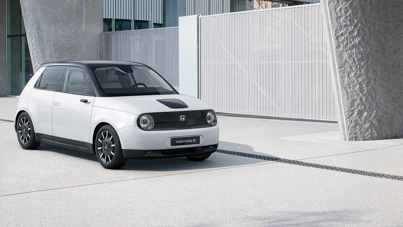 Přední tříčtvrteční pohled na vozidlo Honda e u budovy v noci