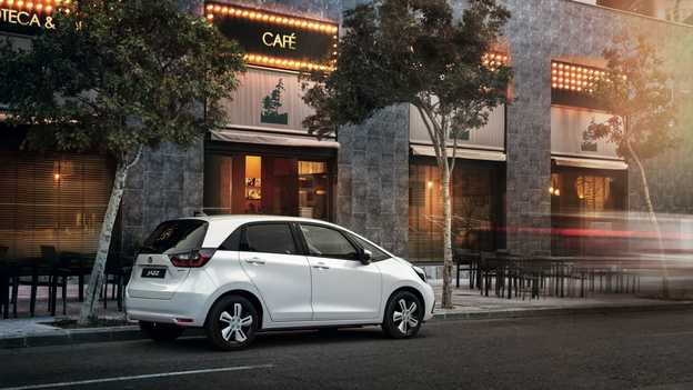 Zadní pohled na model Honda Jazz Hybrid zaparkovaný před kavárnou