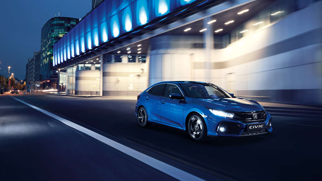 Přední tříčtvrtinový pohled na model Honda Civic. Ve městě.