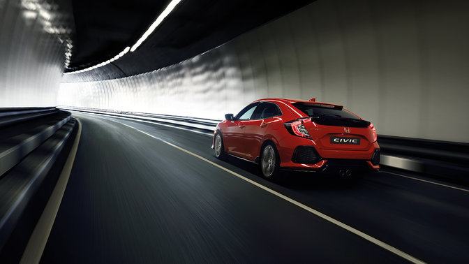 Zadní tříčtvrtinový pohled na model Honda Civic projíždějící tunelem.