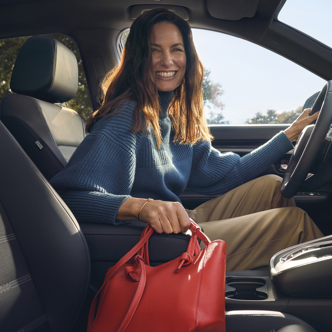 Detailní záběr interiéru vozu Honda CR-V Hybrid zobrazující úložný prostor v loketní opěrce