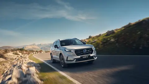 Pohled zepředu na model CR-V Hybrid SUV jedoucí horskou oblastí