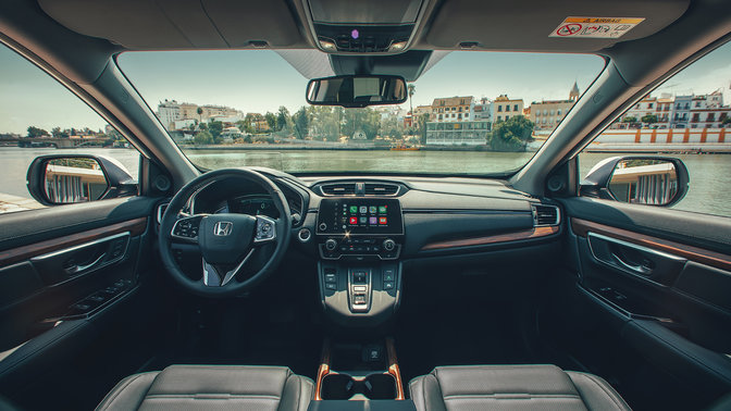 Detailní záběr na palubní desku v interiéru vozu Honda CR-V Hybrid s výhledem na ulici