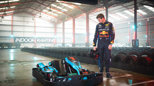 Max Verstappen si prohlíží krytou motokáru.