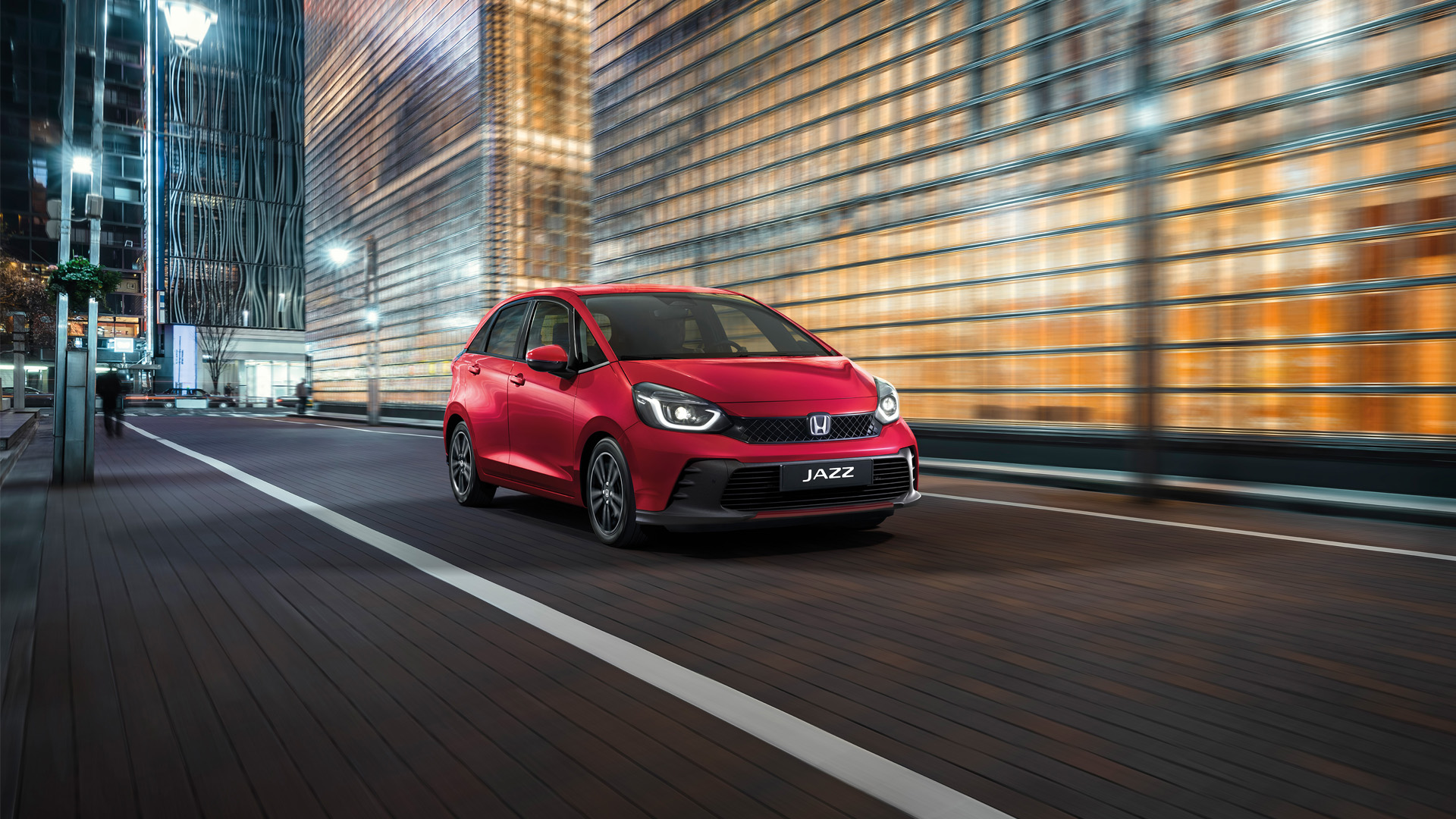 Přední tříčtvrtinový pohled na model Honda Jazz s městem v pozadí