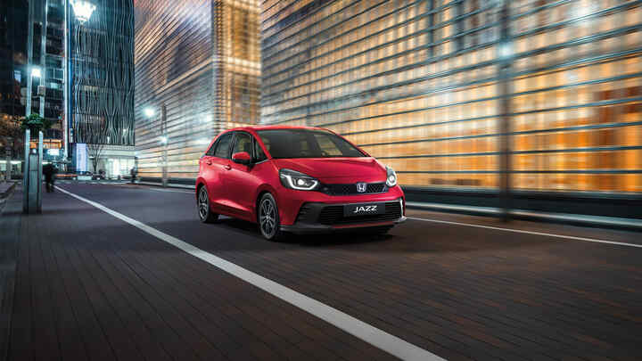 Přední tříčtvrtinový pohled na model Honda Jazz s městem v pozadí