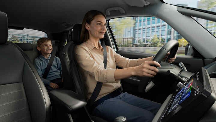 Žena řídící vůz Honda Jazz Hybrid a dítě sedící na zadních sedadlech