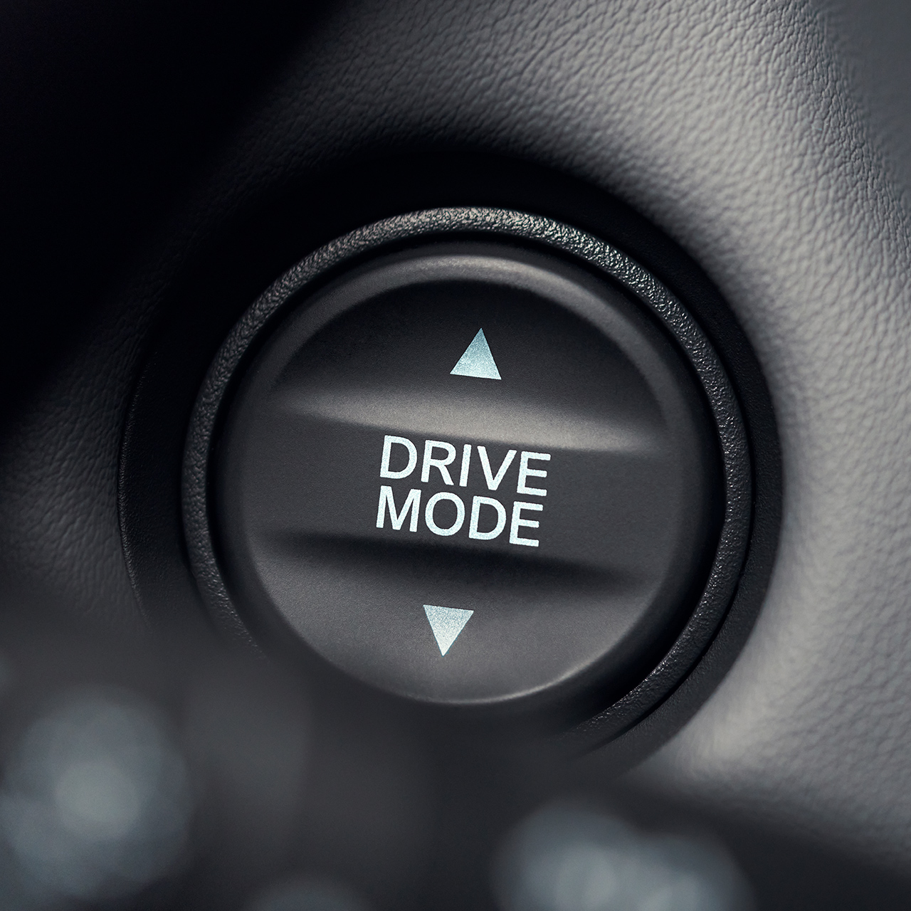 Detailní záběr na tlačítko režimu pohonu s bílým textem