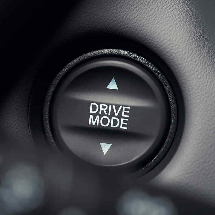 Detailní záběr na tlačítko režimu pohonu s bílým textem