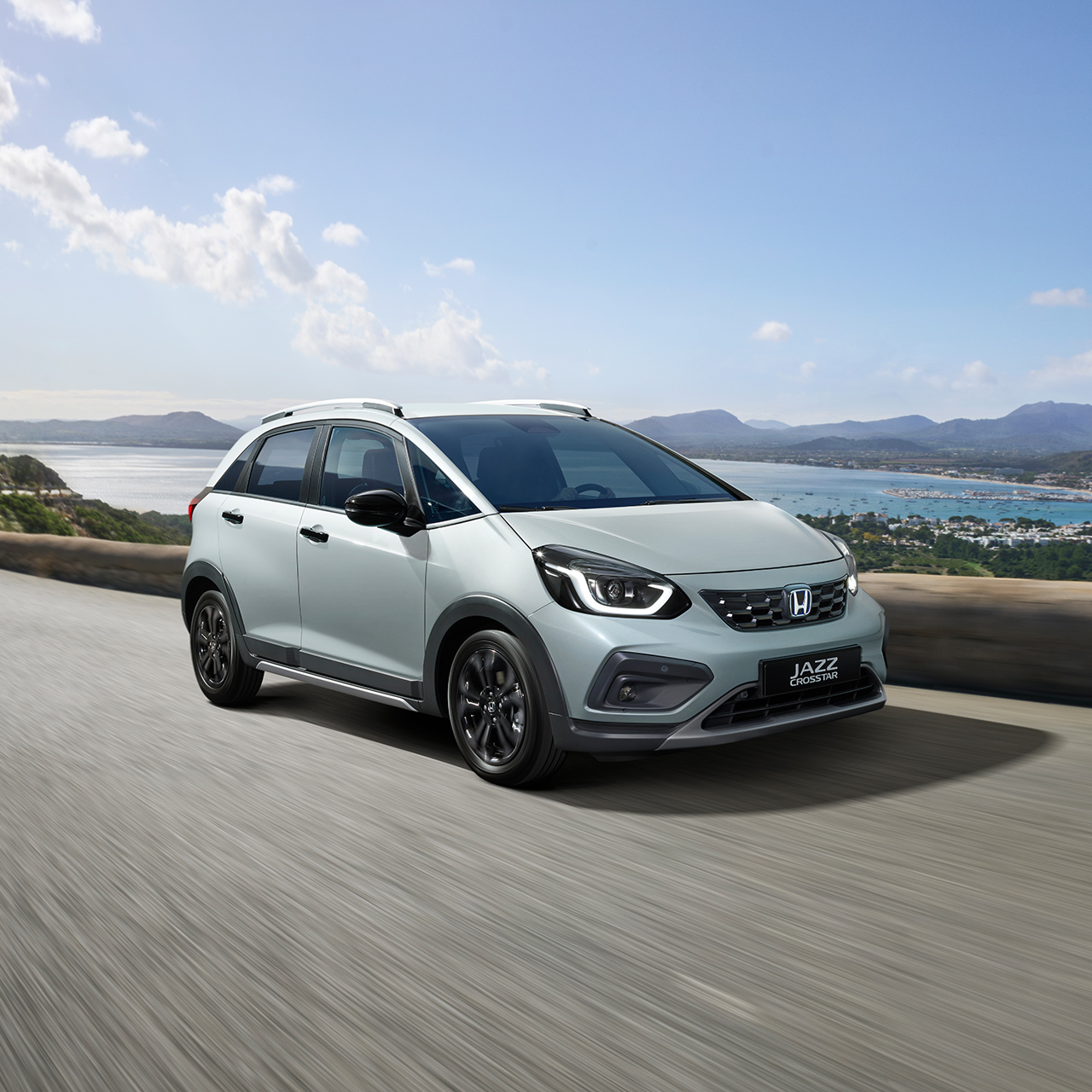 Přední 3/4 pohled na model Honda Jazz Crosstar jedoucího na silnici u pobřeží 