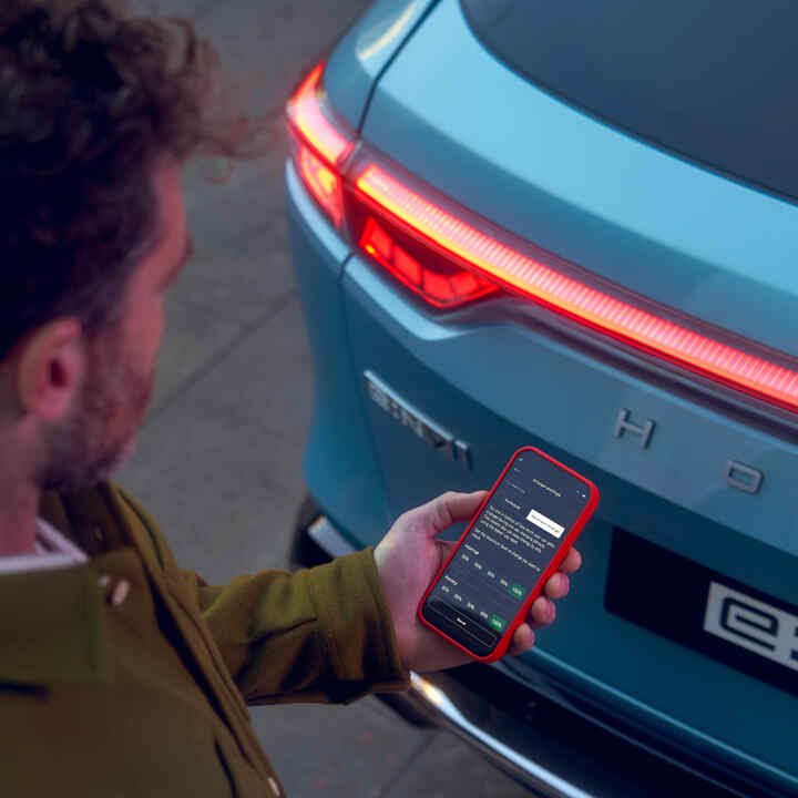 Detailní záběr aplikace My Honda+ na osobu používající smartphone mimo vozidlo