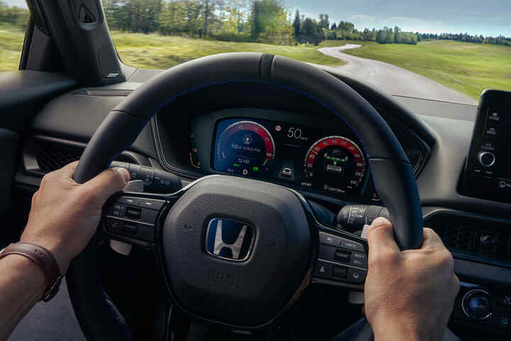 Řidič si užívá interiér Hondy Prelude Hybrid s digitálním kokpitem a pokročilým infotainmentem.