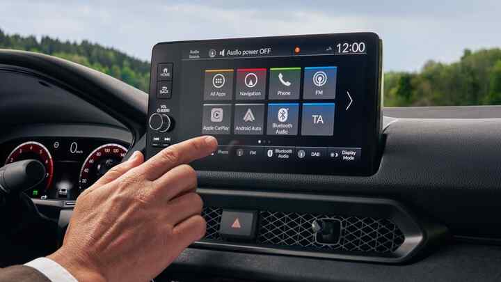 Ruka, která se chystá dotknout obrazovky multimediálního systému vozu Prelude Hybrid.