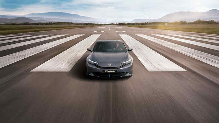 Řidič si užívá interiér Hondy Prelude Hybrid s digitálním kokpitem a pokročilým infotainmentem.