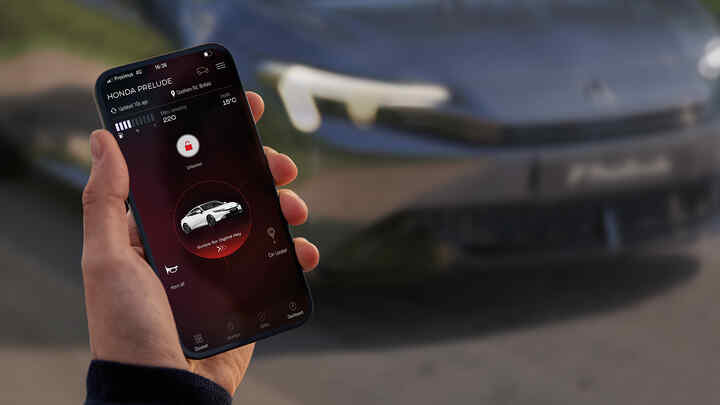 Osoba držící telefon, na kterém je zobrazena aplikace My Honda+.