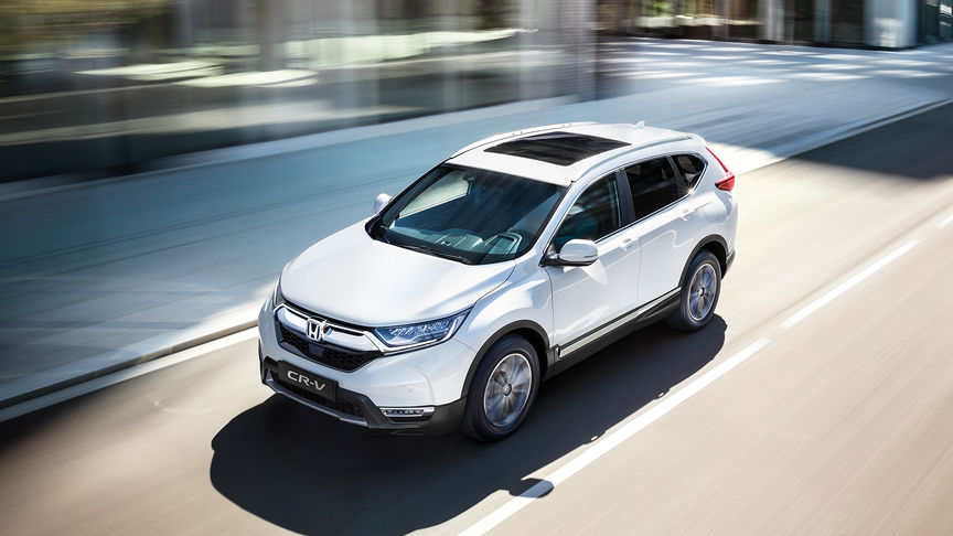 Tříčtvrtinový pohled zepředu na model CR-V při jízdě městem.