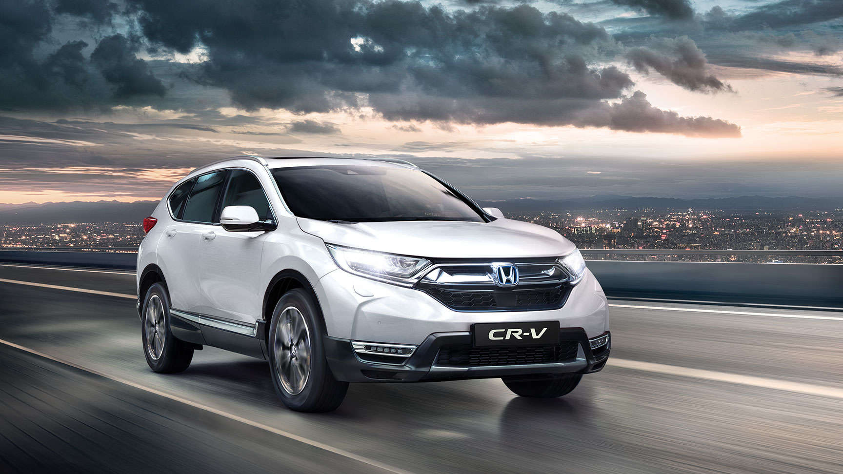 Přední tříčtvrtinový pohled na model Honda CR-V s rozsvícenými dálkovými světlomety
