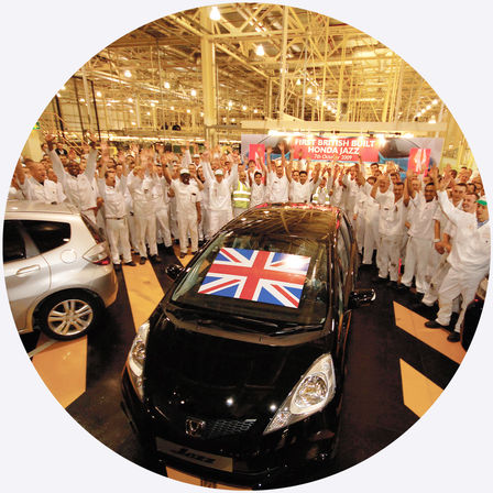 Pohled shora na model Honda Jazz a dělníky v továrně