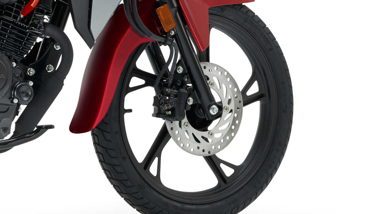 Studiový snímek modelu Honda CB125F v červeném provedení se zaostřením na přední kolo a brzdu