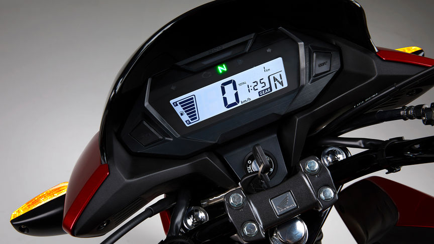 Studiový snímek modelu Honda CB125F v červeném provedení se zaostřením na inteligentní digitální přístrojový panel