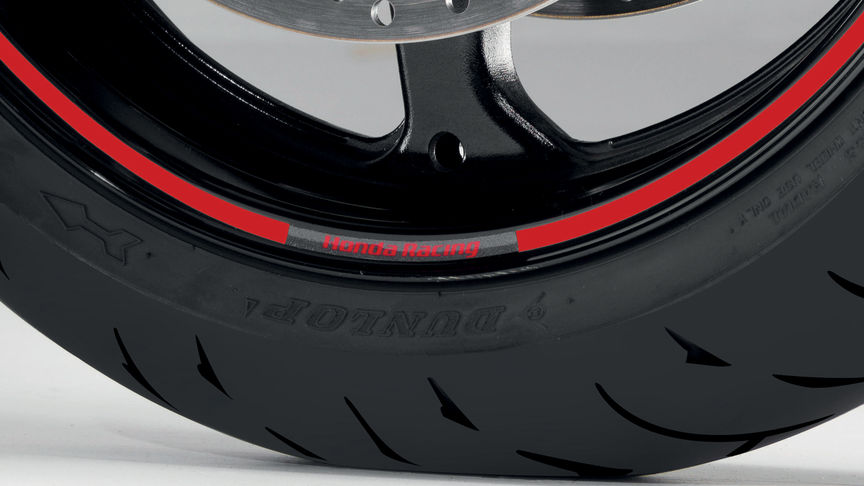 Detailní snímek kola motocyklu s nálepkou Honda.