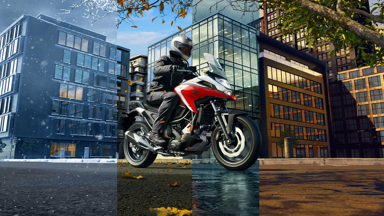 Honda NC750X, pravý přední poloprofil s jezdcem, různé klimatické podmínky, červený motocykl