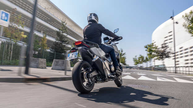 Pohled zezadu na motocykl Honda X-ADV při jízdě městem.