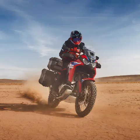 Jezdec na modelu Honda CRF1100 Africa Twin Adventure Sport v poušti.