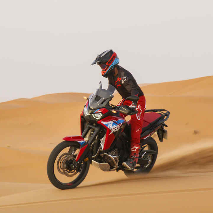 Figurant jedoucí na motocyklu CRF1100L Africa Twin na silnici v poušti