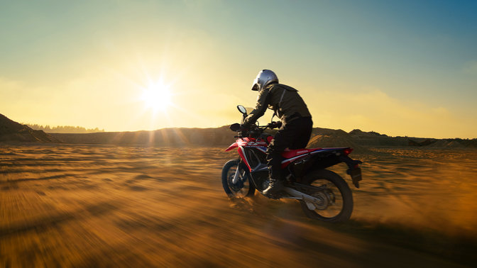 Levý poloprofil motocyklu Honda CRF250 EX Rally s jezdcem.