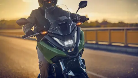 Přední záběr figuranta jedoucího na motocyklu NC750X na silnici