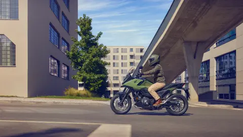 Boční záběr figuranta jedoucího na motocyklu NC750X ve městě
