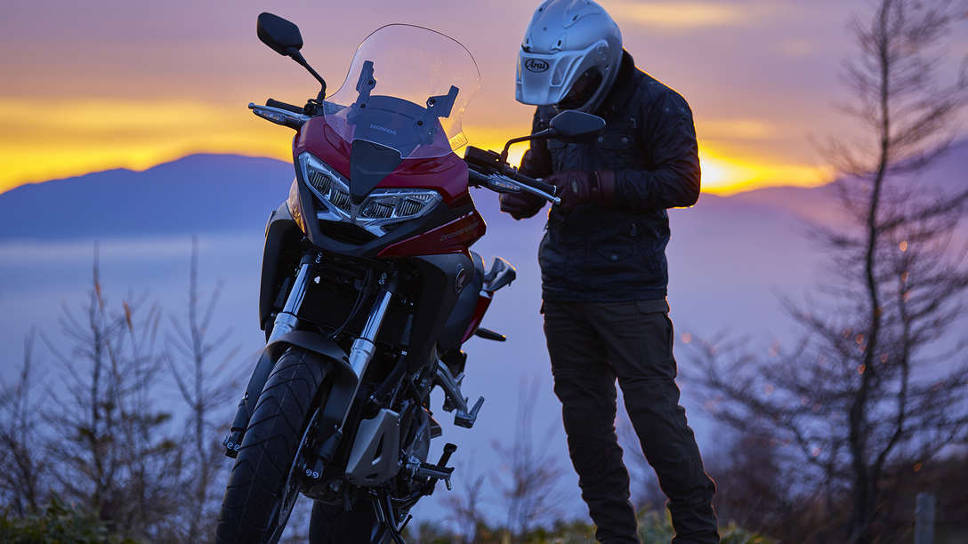 Model VFR800X zaparkovaný na venkově s vedle stojícím jezdcem
