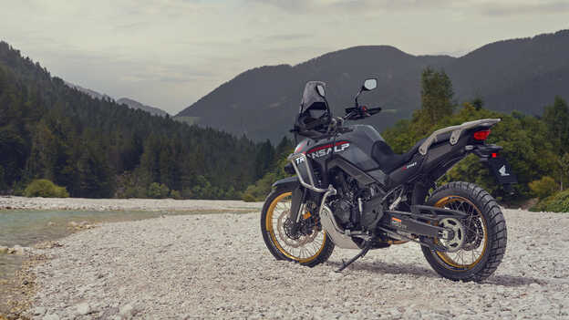 Jezdec drží motocykl XL750 Transalp v horském prostředí.