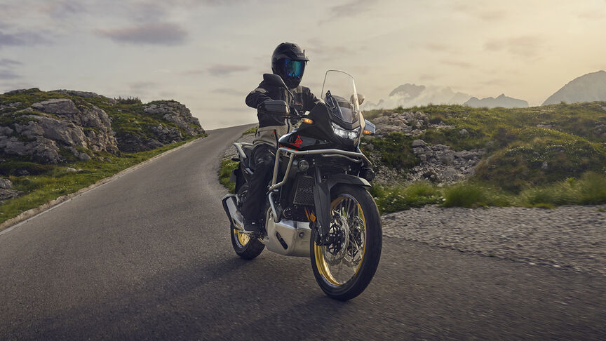 Figurant jedoucí na motocyklu XL750 Transalp v lese