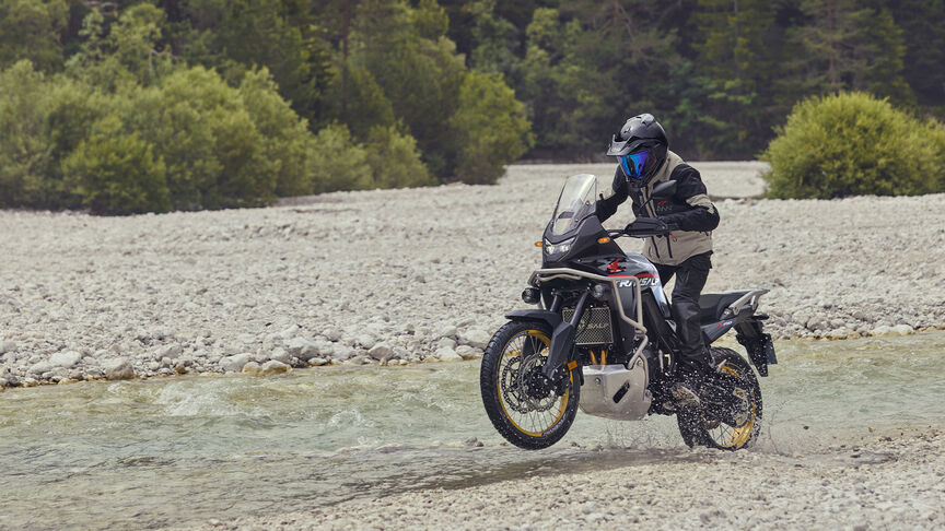 Figurant jedoucí na motocyklu XL750 Transalp v lese
