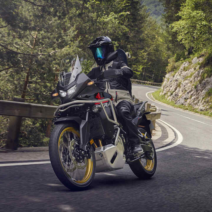 Model na motocyklu XL750 Transalp v horském prostředí.
