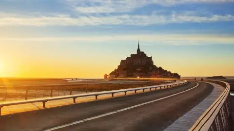 Cesta na Mont-Saint-Michel při západu slunce, Normandie, Francie