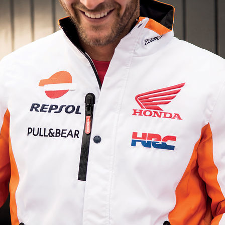 Usmívající se muž v závodní bundě Honda