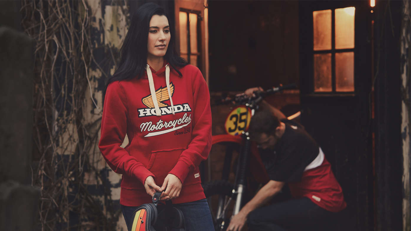 Muž a ženy v červené retro mikině Honda. 