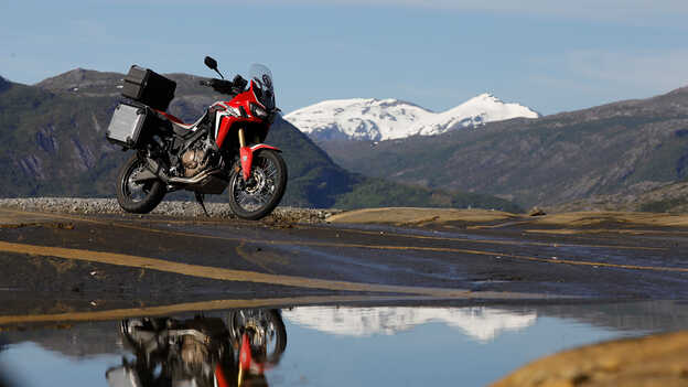 Statický snímek motocyklu Africa Twin s horami v pozadí