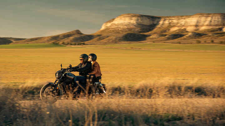 CMX1100 Rebel with rider and pillion on road at dusk