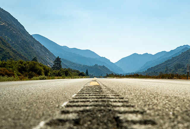 Volná asfaltová silnice vedoucí směrem k horám