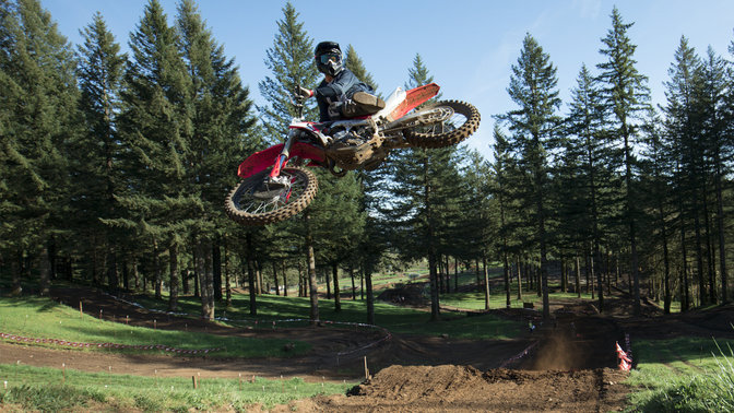 Model CRF450R ve skoku s jezdcem. Na polní cestě.