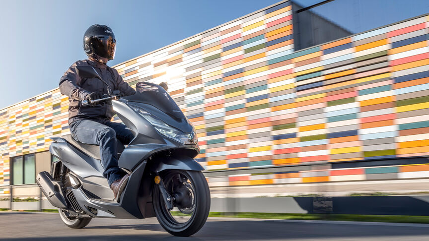 Honda PCX125 – Tříčtvrtinový dynamický snímek zezadu s jezdcem