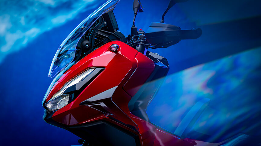 Přední 3/4 pohled na model Honda ADV350 u pobřeží