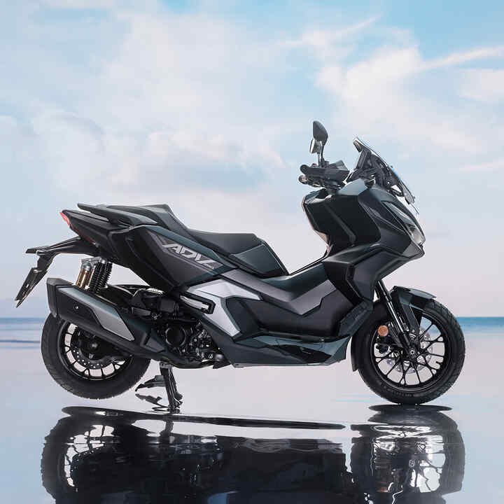 Boční pohled na Hondu ADV350 v pobřežní oblasti. 