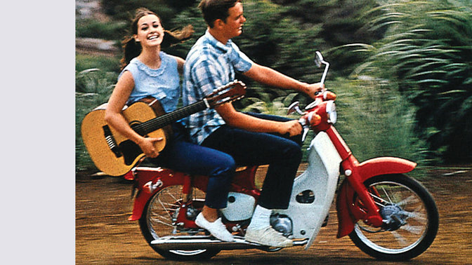 Model Honda Cub s jezdcem a spolujezdcem s kytarou Na polní cestě. Pohled z pravé strany.